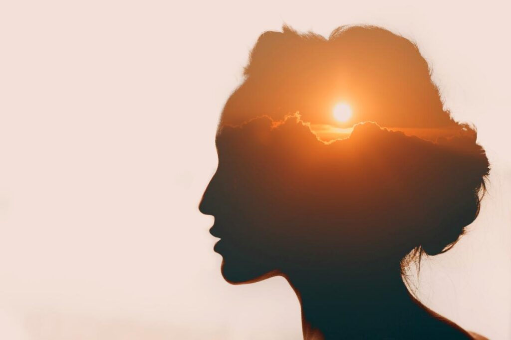 silhouette of a womans head with sunset the woman thinks about dependence vs addiction